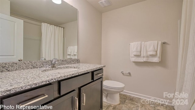 bathroom featuring toilet, baseboards, visible vents, and vanity