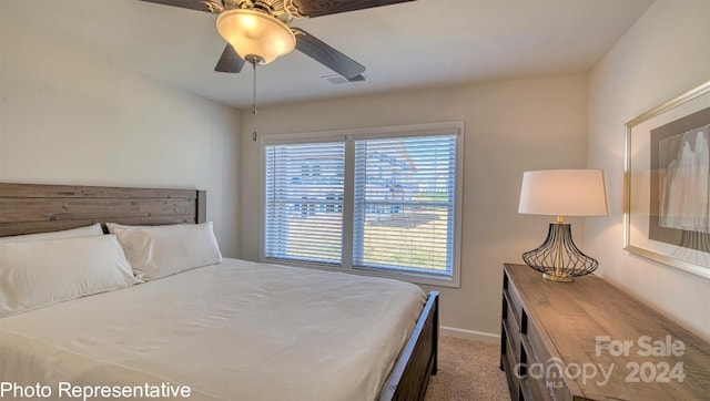 carpeted bedroom featuring a ceiling fan, visible vents, and baseboards