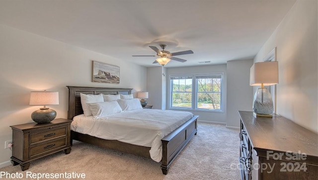 bedroom featuring visible vents, baseboards, ceiling fan, and light colored carpet