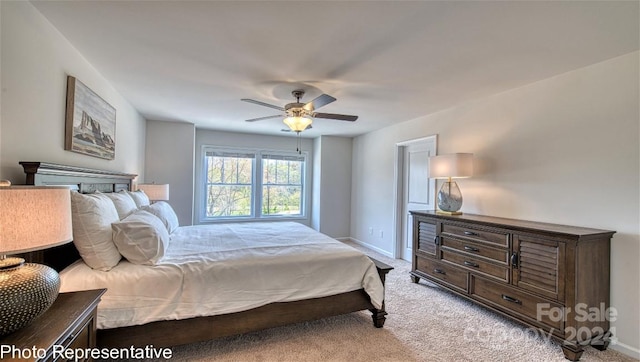 bedroom featuring baseboards, a ceiling fan, and light colored carpet