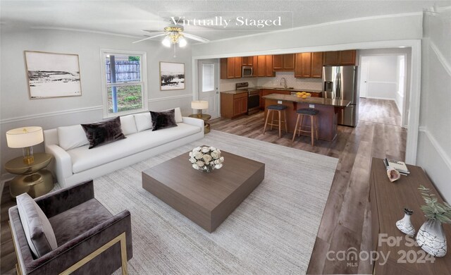 living room with dark wood-type flooring, sink, and ceiling fan