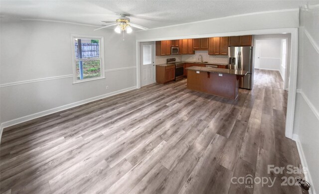 kitchen featuring sink, appliances with stainless steel finishes, ceiling fan, and hardwood / wood-style floors