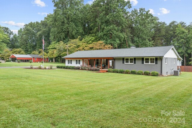 ranch-style house featuring a front lawn and cooling unit