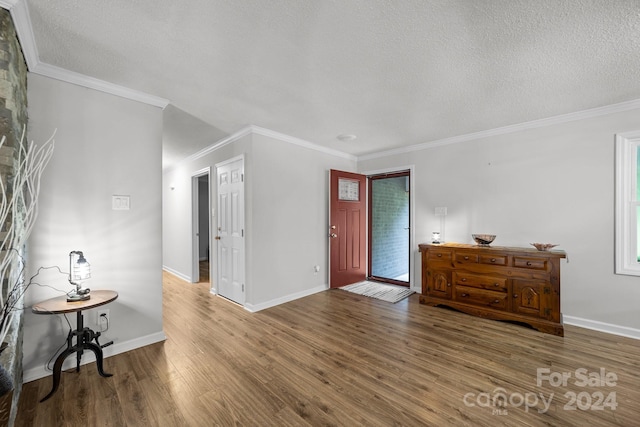 foyer entrance featuring hardwood / wood-style floors, crown molding, and a textured ceiling