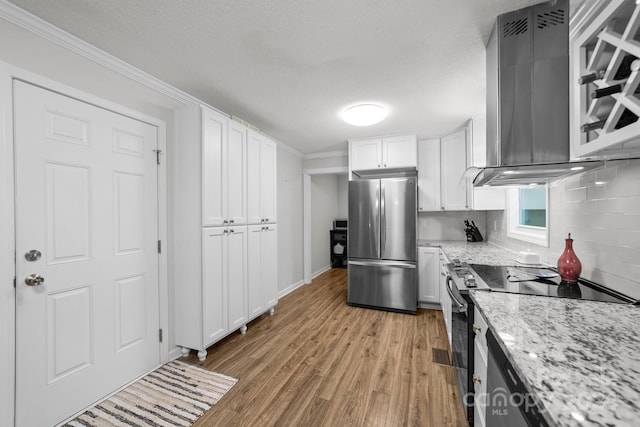 kitchen featuring crown molding, light hardwood / wood-style flooring, white cabinets, range with electric stovetop, and stainless steel fridge