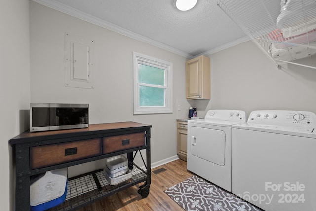 clothes washing area with cabinets, separate washer and dryer, a textured ceiling, light wood-type flooring, and ornamental molding