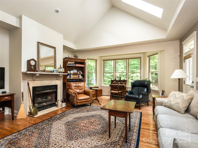 living room featuring hardwood / wood-style flooring, a fireplace, high vaulted ceiling, and a wealth of natural light