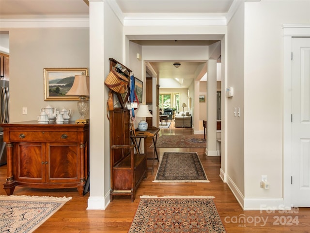 hallway with hardwood / wood-style floors and ornamental molding