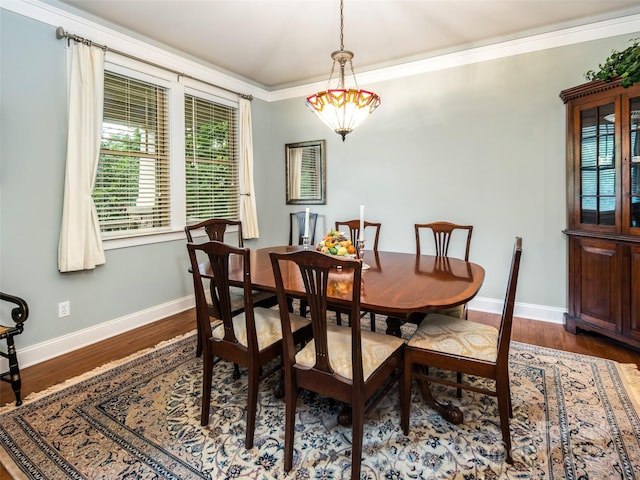 dining room with crown molding and dark wood-type flooring