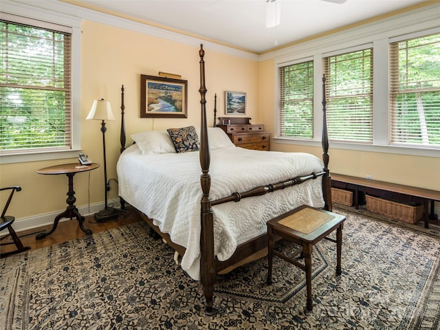 bedroom featuring wood-type flooring, ornamental molding, and ceiling fan