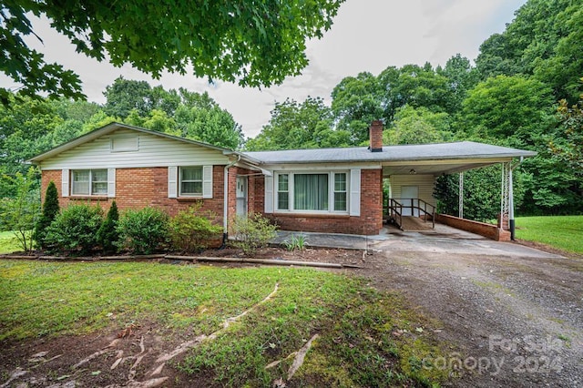 ranch-style home featuring a front lawn and a carport