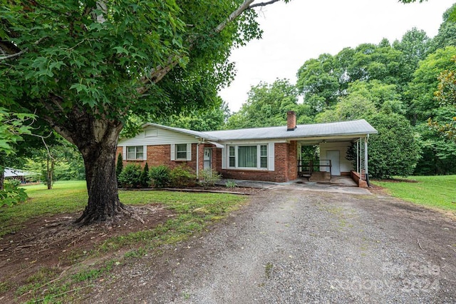 ranch-style home featuring a front yard and a carport