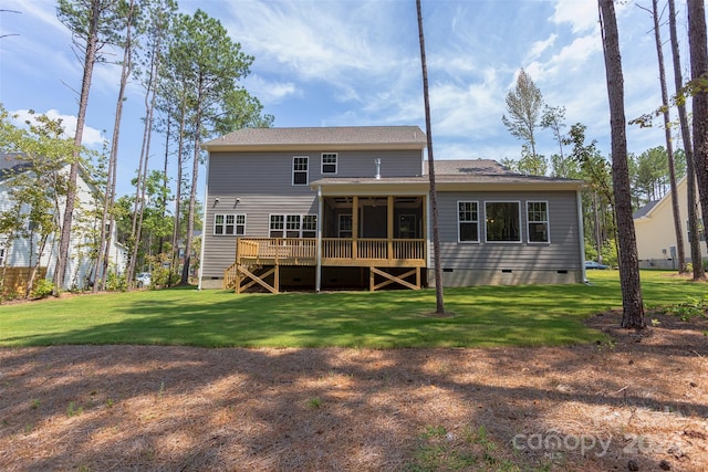 rear view of property featuring a sunroom, a deck, and a lawn