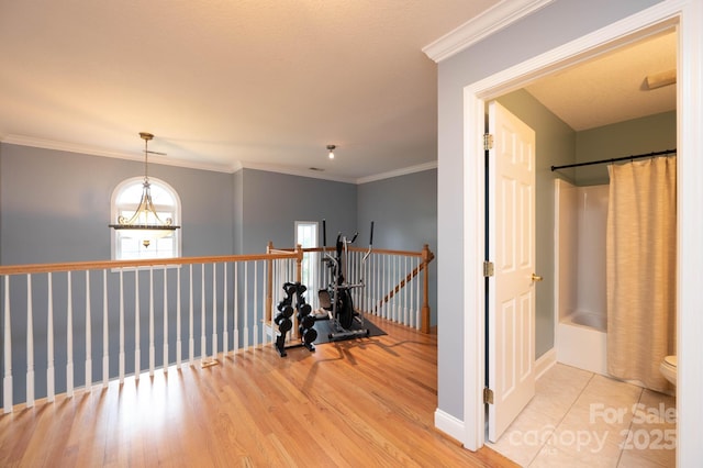 hallway featuring light wood-type flooring and ornamental molding