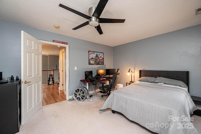 bedroom with a textured ceiling, ceiling fan, and carpet floors