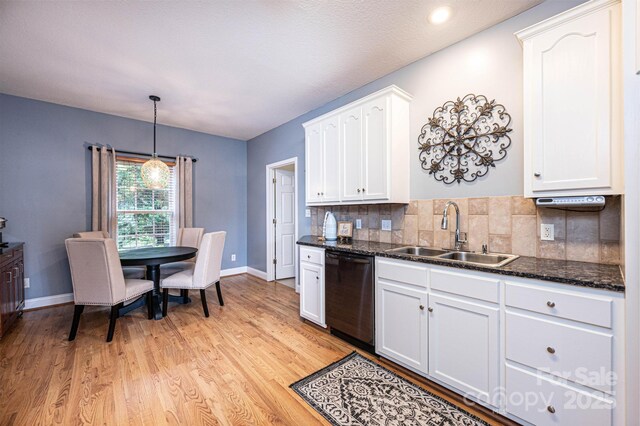 kitchen featuring tasteful backsplash, dishwasher, pendant lighting, sink, and white cabinets