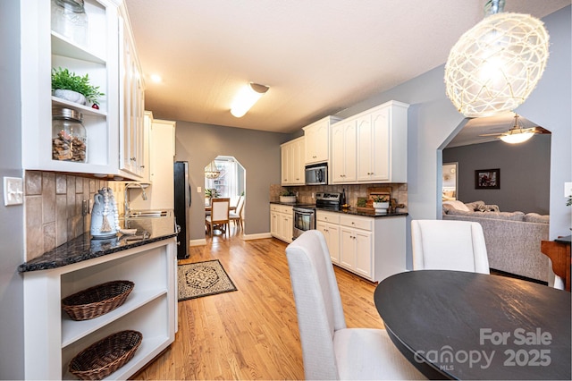 kitchen with white cabinetry, hanging light fixtures, stainless steel appliances, and tasteful backsplash