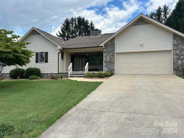 single story home with a garage and a front yard