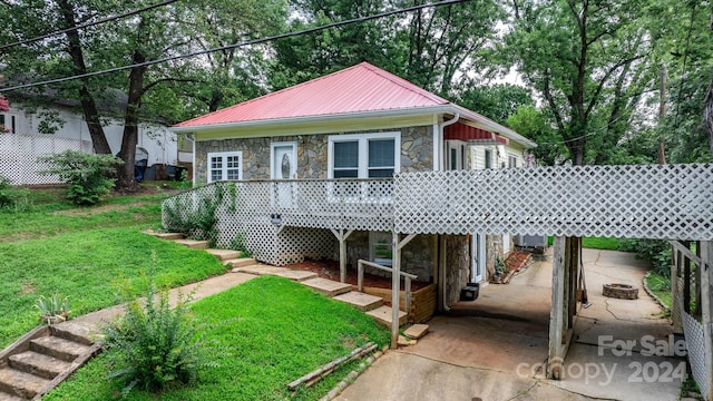 back of property with a deck and a yard