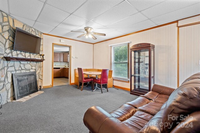 living room featuring a drop ceiling, carpet, and ceiling fan