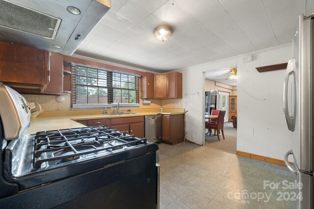 kitchen with appliances with stainless steel finishes, sink, light tile patterned floors, crown molding, and ceiling fan