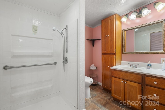 bathroom featuring tiled shower, toilet, vanity, tile patterned floors, and ornamental molding