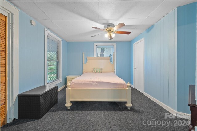 bedroom with a drop ceiling, carpet floors, and ceiling fan