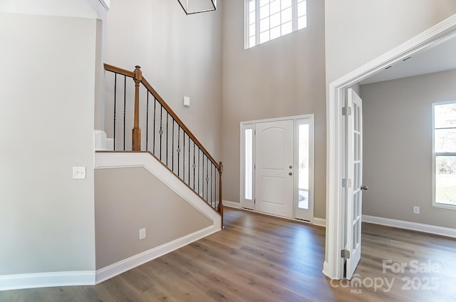 foyer entrance with hardwood / wood-style floors and a high ceiling