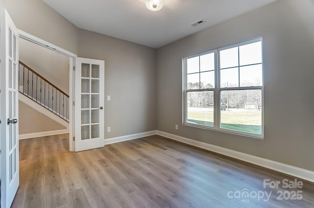 spare room featuring french doors and light wood-type flooring