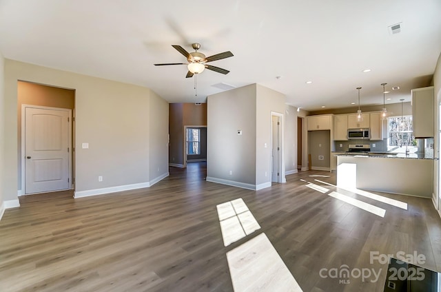 unfurnished living room with ceiling fan and dark wood-type flooring