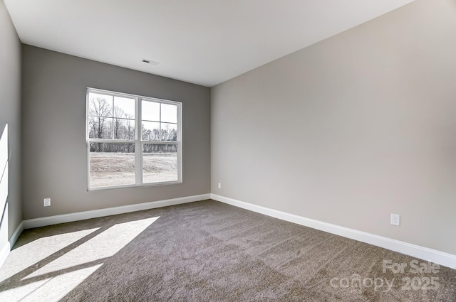 unfurnished room featuring dark colored carpet