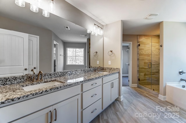 bathroom featuring shower with separate bathtub, hardwood / wood-style flooring, and vanity