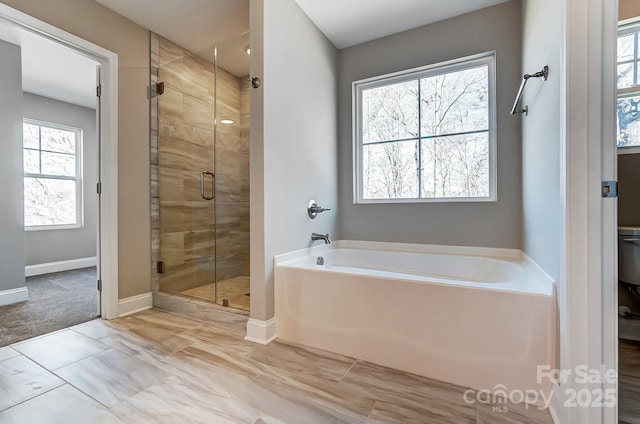 bathroom featuring shower with separate bathtub