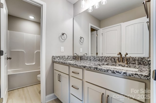 full bathroom with shower / bathing tub combination, hardwood / wood-style floors, toilet, and vanity