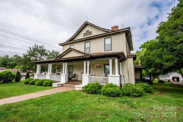 view of front of house with covered porch and a front lawn