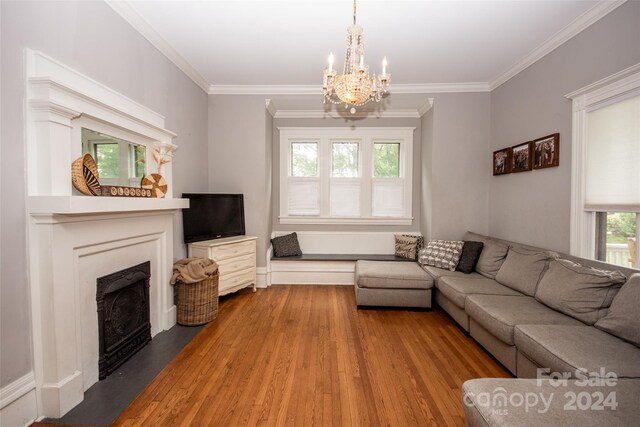 living room with an inviting chandelier, wood-type flooring, and ornamental molding