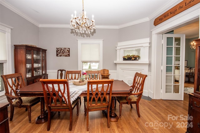 dining room with crown molding, a chandelier, and light hardwood / wood-style flooring