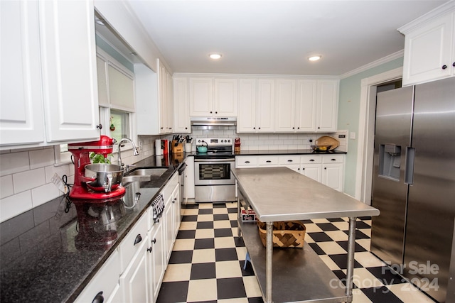 kitchen with tasteful backsplash, white cabinetry, appliances with stainless steel finishes, and sink