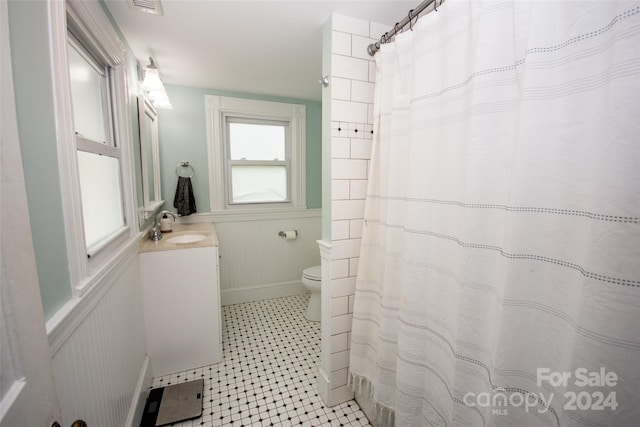 bathroom with walk in shower, vanity, and toilet