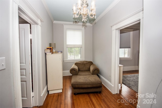 living area with hardwood / wood-style flooring and ornamental molding