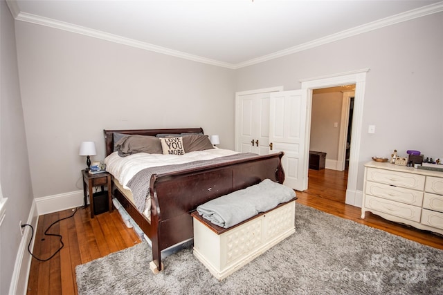 bedroom featuring hardwood / wood-style flooring, ornamental molding, and a closet