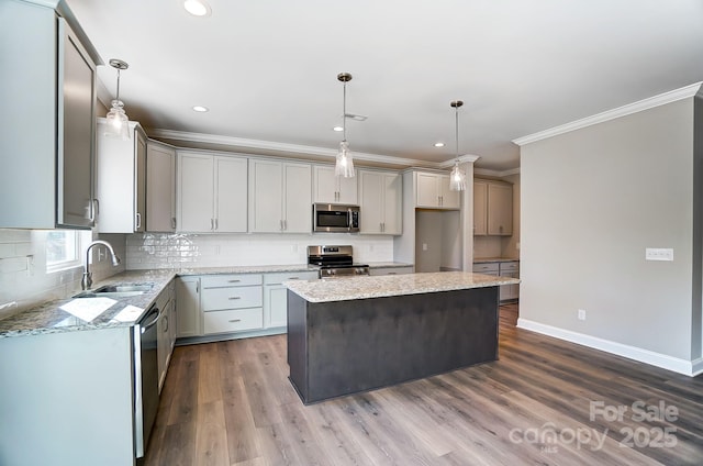 kitchen with pendant lighting, a kitchen island, dark hardwood / wood-style flooring, stainless steel appliances, and sink