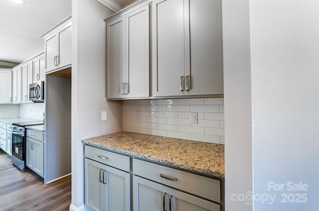 kitchen with light hardwood / wood-style floors, appliances with stainless steel finishes, tasteful backsplash, crown molding, and light stone counters