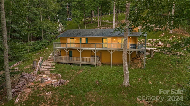 rear view of property with metal roof, stairs, a yard, a wooden deck, and log veneer siding