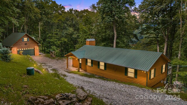 log home featuring an outdoor structure and a garage