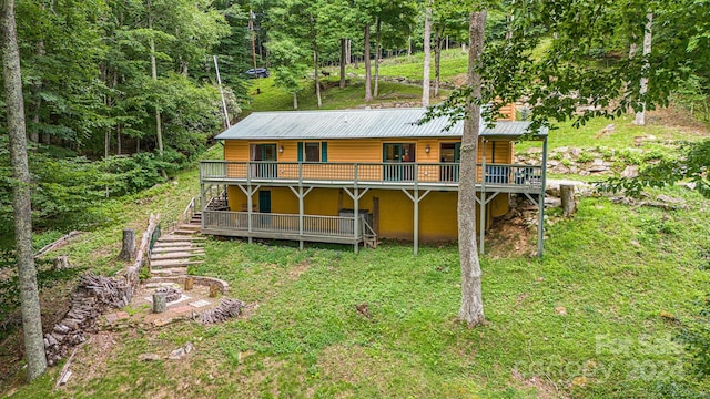 rear view of property with stairs, metal roof, and a wooden deck