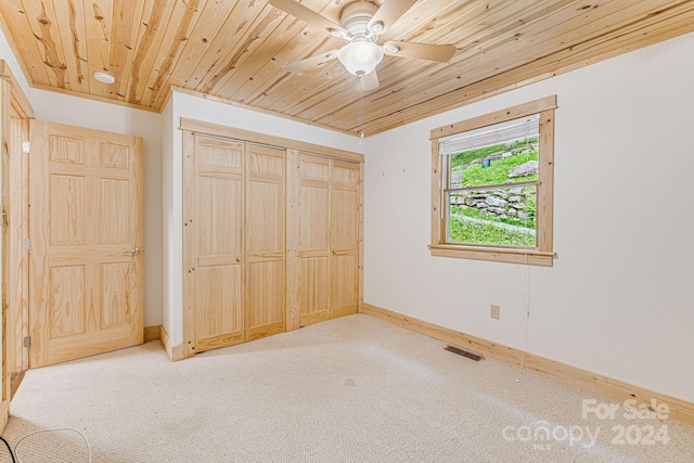 unfurnished bedroom with wood ceiling, carpet, visible vents, and baseboards