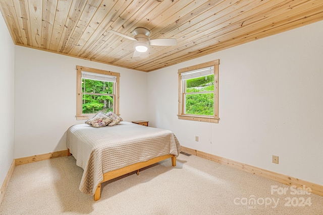 bedroom with a ceiling fan, multiple windows, wood ceiling, and baseboards