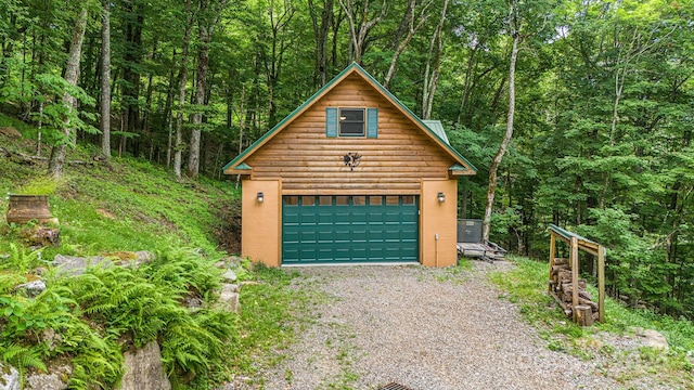 garage with a detached garage and a forest view