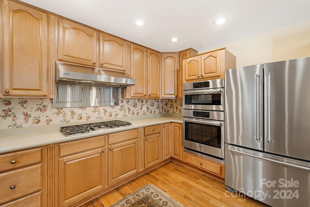 kitchen featuring light brown cabinets, stainless steel appliances, and light hardwood / wood-style floors